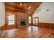 Vaulted living room with stone fireplace, hardwood floors and access to a patio at 7545 Ne 58Th Ave, Anthony, FL 32617