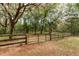 Wooden fence with a metal gate leading to a wooded area at 7545 Ne 58Th Ave, Anthony, FL 32617