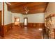 Living area with hardwood floors, wood-paneled walls, and a view of the bathroom at 7545 Ne 58Th Ave, Anthony, FL 32617