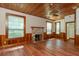 Spacious living room with wood-paneled walls, a stone fireplace, and hardwood floors at 7545 Ne 58Th Ave, Anthony, FL 32617