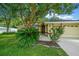 House entrance with lush landscaping and a large tree at 5311 Se 15Th Ct, Ocala, FL 34480