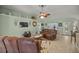 Spacious living room featuring brown leather furniture and tile floors at 3967 Se 99Th St, Belleview, FL 34420