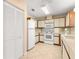 Galley-style kitchen with white appliances and light wood cabinets at 9460 Sw 84Th Ter # D, Ocala, FL 34481