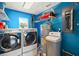 Laundry room with washer, dryer, water heater, and shelving at 10 Se Chinica Drive, Summerfield, FL 34491