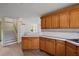 Kitchen with wood cabinets, tile countertops, and a view of the staircase at 10 Se Chinica Drive, Summerfield, FL 34491