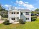 Two-story house with light yellow siding, gray roof, and a well-manicured lawn at 10 Se Chinica Drive, Summerfield, FL 34491