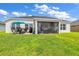 Large backyard with patio, covered lanai and grassy area at 1789 Usrey Ct, The Villages, FL 34762