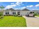 Single-story home with a two-car garage and landscaped yard at 1789 Usrey Ct, The Villages, FL 34762