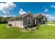 Side view of a one-story house with taupe exterior and landscaping at 25 Nw 45Th Loop, Ocala, FL 34475