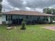 Ranch-style home with covered porch and green lawn at 6690 Cherry Rd, Ocala, FL 34472