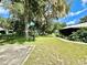Large backyard with patio, mature trees, and a partially fenced area at 26 Juniper Pass Ln, Ocala, FL 34480