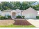 Single-story house with pink exterior, two-car garage and manicured lawn at 11696 Sw 71St Cir, Ocala, FL 34476