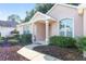 Front view of a pink house with landscaping and walkway at 11696 Sw 71St Cir, Ocala, FL 34476