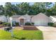 Pink single-story house with a two-car garage and well-maintained lawn at 11696 Sw 71St Cir, Ocala, FL 34476