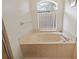 Relaxing bathroom with a corner jacuzzi tub and window at 10716 Sw 53Rd Cir, Ocala, FL 34476