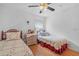 Two twin beds, a dresser, and ceiling fan in a bright bedroom at 10716 Sw 53Rd Cir, Ocala, FL 34476