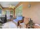 Cozy screened porch featuring wicker furniture and ceiling fan at 10716 Sw 53Rd Cir, Ocala, FL 34476