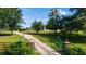 Long driveway leads to a home with a green gate at 174 Juniper Trl, Ocala, FL 34480