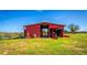 Red barn with tractor and riding mower at 174 Juniper Trl, Ocala, FL 34480