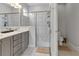 Spa-like bathroom with a large walk-in shower, marble tile, and modern gold fixtures at 7694 Graben St, Kissimmee, FL 34747