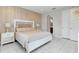 Bright bedroom with king bed, neutral decor, and marble-tiled floors. Access to en-suite bathroom at 7694 Graben St, Kissimmee, FL 34747