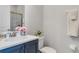 Clean bathroom with navy blue vanity, a shower, and white toilet at 7694 Graben St, Kissimmee, FL 34747