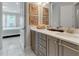 Double vanity bathroom with gray cabinets, quartz countertops, and a view into the bedroom at 7694 Graben St, Kissimmee, FL 34747