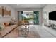 Bright living room with sliding glass doors leading to a pool view, featuring comfortable seating and modern decor at 7694 Graben St, Kissimmee, FL 34747