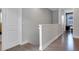 Upstairs hallway with wood flooring and access to bedrooms at 7694 Graben St, Kissimmee, FL 34747