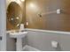 Elegant powder room with a pedestal sink, gold fixtures, and decorative wallpaper at 7694 Graben St, Kissimmee, FL 34747