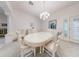 Formal dining room with an oval table, white chairs, and a chandelier at 1153 Oak Forest Dr, The Villages, FL 32162