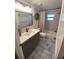 Updated bathroom with gray vanity, subway tile, and a large shower/tub at 1965 County Road 243C, Wildwood, FL 34785