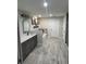 Spa-like bathroom with double vanity, soaking tub, and gray wood-look floors at 1965 County Road 243C, Wildwood, FL 34785