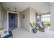 Inviting front porch featuring a blue door and comfortable seating at 8924 Sw 76Th Ln, Ocala, FL 34481