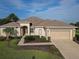 One-story home with a two-car garage, manicured lawn and landscaping at 9240 Se 128Th Ln, Summerfield, FL 34491