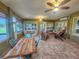 Sunroom features ample natural light and comfortable furniture at 9240 Se 128Th Ln, Summerfield, FL 34491