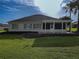 Back of house with a large covered patio and golf course view at 9240 Se 128Th Ln, Summerfield, FL 34491