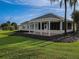 House back view with a large covered patio and lush landscaping at 9240 Se 128Th Ln, Summerfield, FL 34491