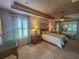 Main bedroom with a king-size bed, window seat, and large windows at 9240 Se 128Th Ln, Summerfield, FL 34491