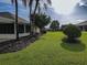 Landscaped backyard with mature trees and green lawn at 9240 Se 128Th Ln, Summerfield, FL 34491
