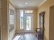 Bright entryway with tiled floor, coat rack, and decorative mirror at 9240 Se 128Th Ln, Summerfield, FL 34491