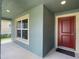 Covered front porch with a red door and window at 4426 Nw 2Nd Ct, Ocala, FL 34475