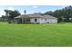 House exterior showcasing a covered patio and lush lawn at 1620 Nw 73Rd Ter, Ocala, FL 34482