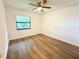 Bright bedroom with wood-look floors, ceiling fan, and large window at 21389 Sw 102Nd Street Rd, Dunnellon, FL 34431