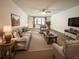 Living room with comfy furniture, wood-look floors, and large windows at 21389 Sw 102Nd Street Rd, Dunnellon, FL 34431