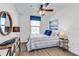 Bright bedroom with a ceiling fan, wood-look floors, and large window at 6595 Sw 81St Loop, Ocala, FL 34476