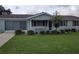 Ranch-style home with carport, mature landscaping, and lawn at 8750 Sw 116Th Place Rd, Ocala, FL 34481