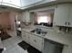 Kitchen with double sink, dishwasher and pass-through to dining area at 8750 Sw 116Th Place Rd, Ocala, FL 34481