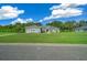 Gray house with green lawn and blue sky, viewed from street at 1934 Nw 79Th Loop, Ocala, FL 34475