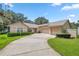 Tan house with three-car garage and landscaped yard at 11196 Ne 227Th Place Rd, Fort Mc Coy, FL 32134